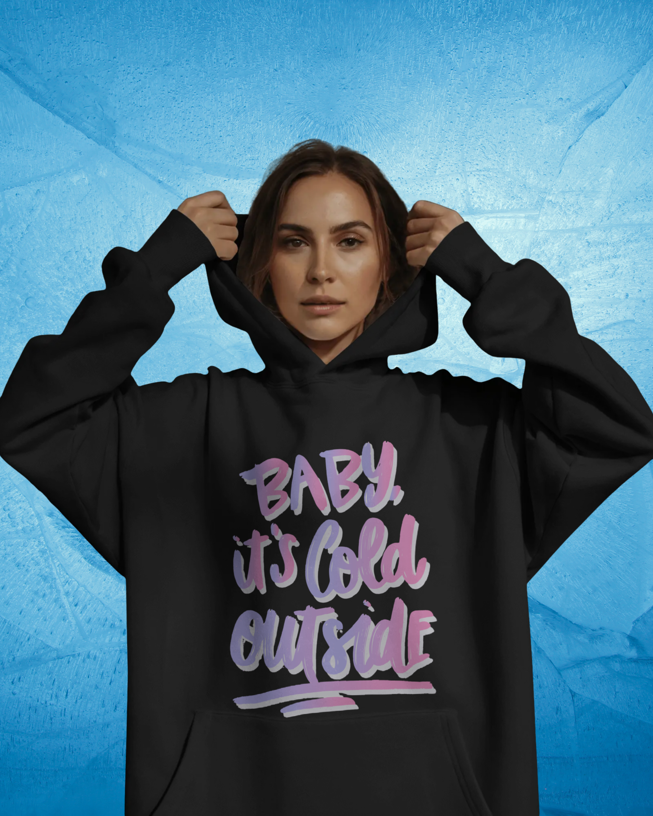 Person wearing a black hoodie with 'Baby, it's cold outside' text on a blue textured background