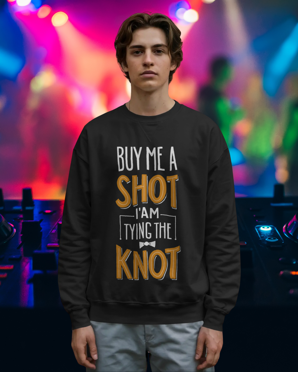 Person wearing a black sweatshirt with humorous text in a colorful indoor setting