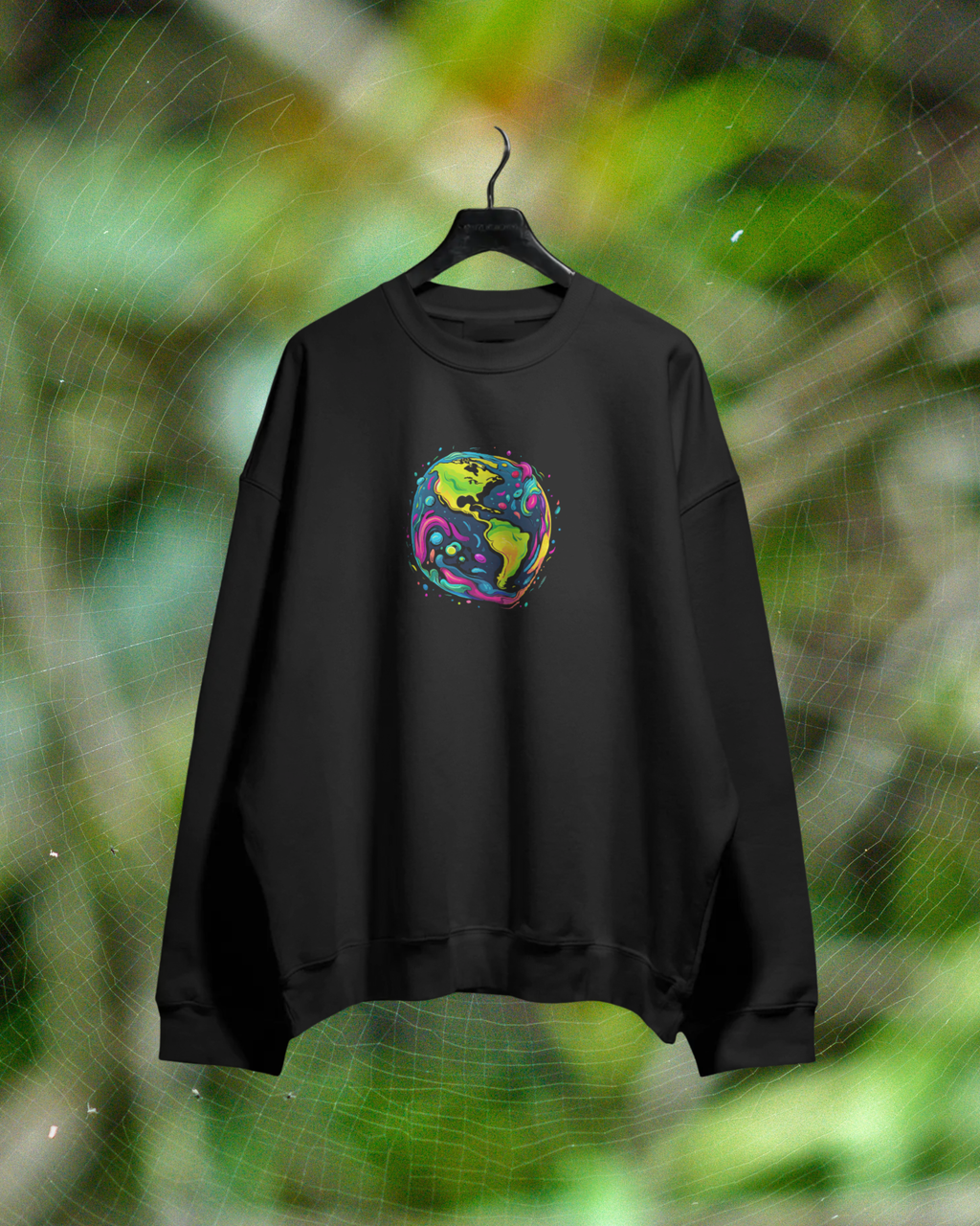 Black sweatshirt with a colorful graphic on a hanger against a green leafy background