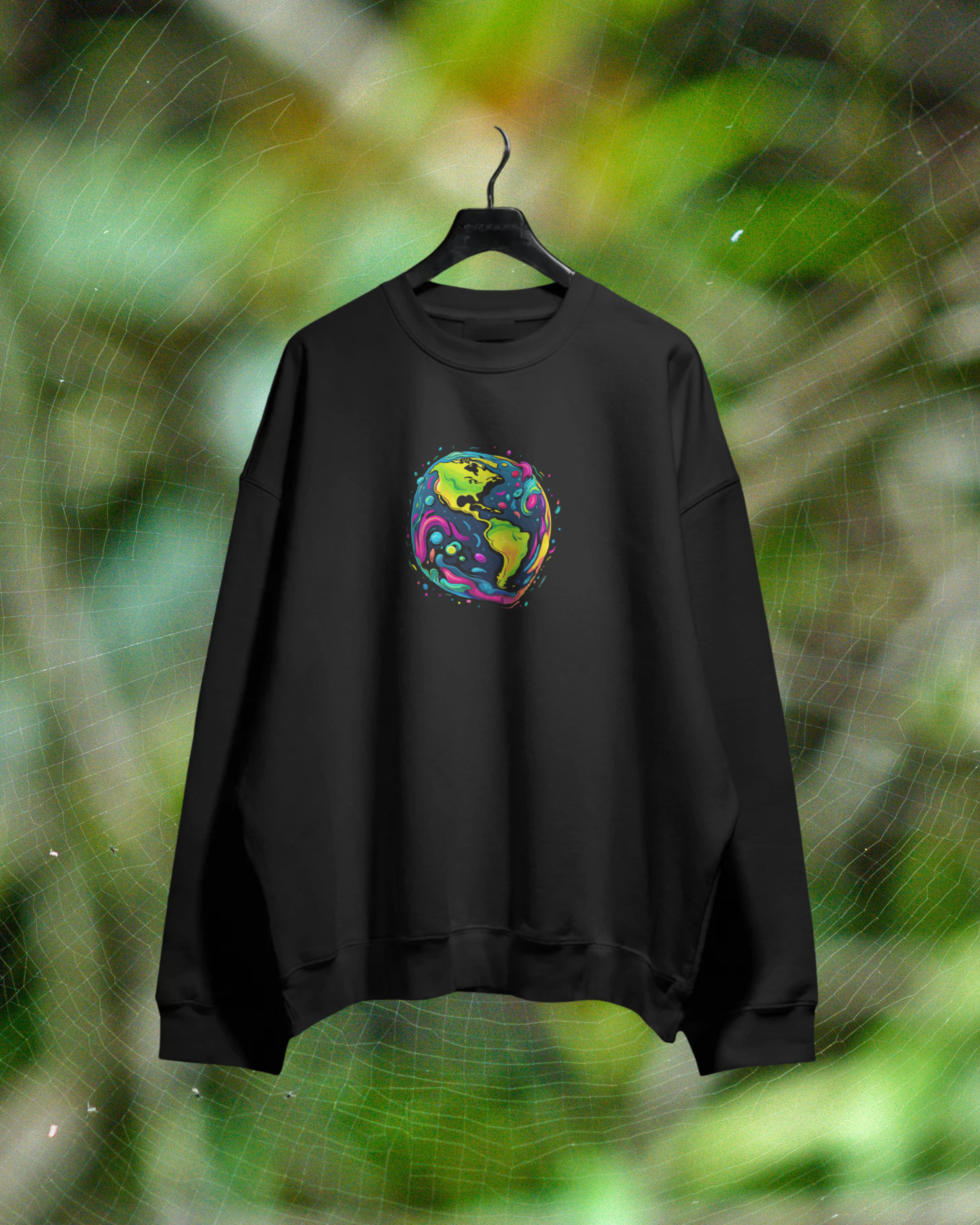 Black sweatshirt with a colorful graphic on a hanger against a green leafy background
