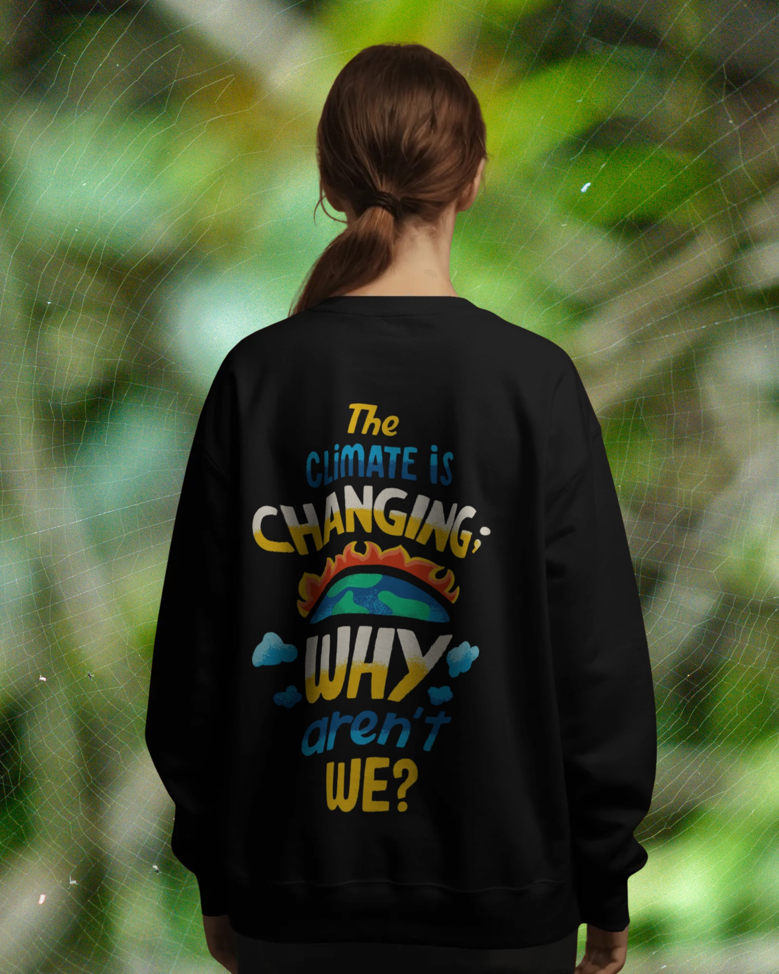 Person wearing a black sweatshirt with environmental message in nature setting