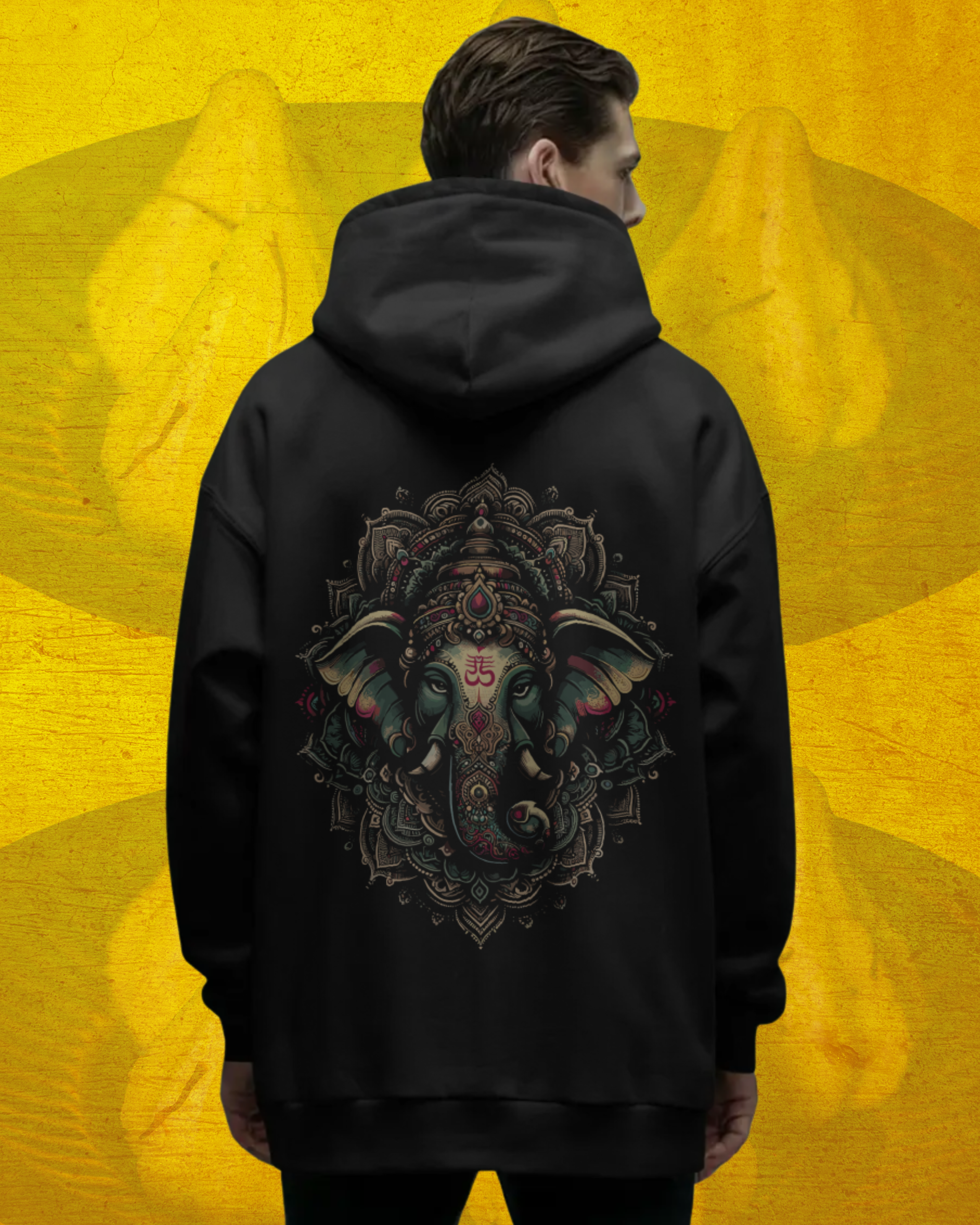 Person wearing a black hoodie with a colorful elephant design on the back against a yellow background