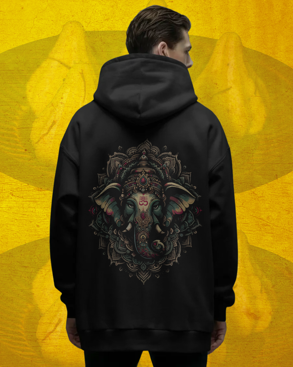 Person wearing a black hoodie with a colorful elephant design on the back against a yellow background