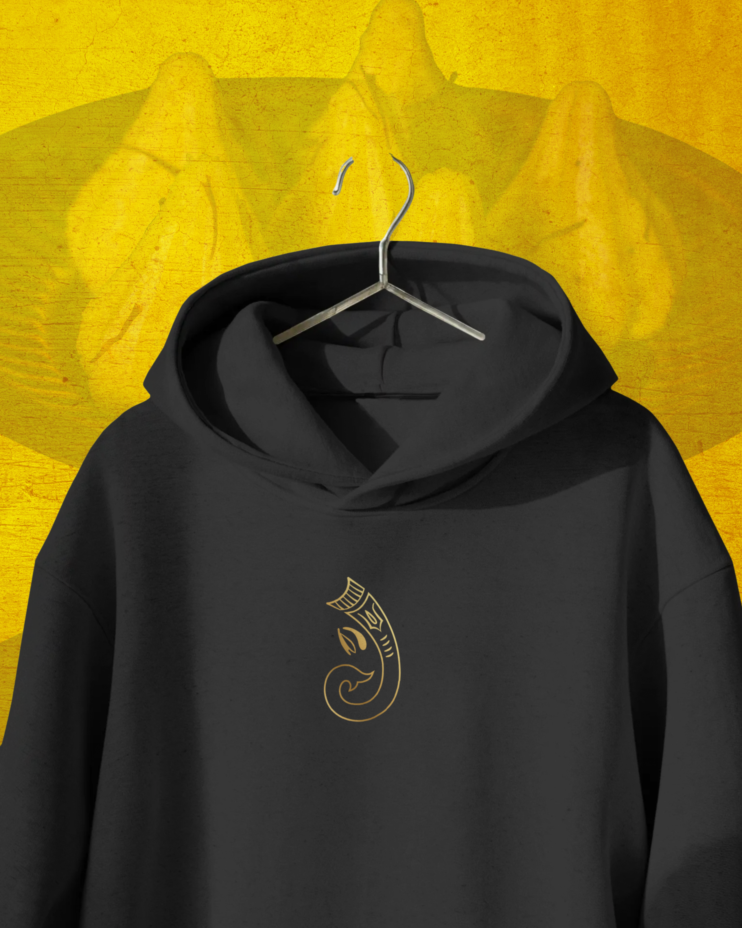 Black hoodie with a gold emblem on a yellow background