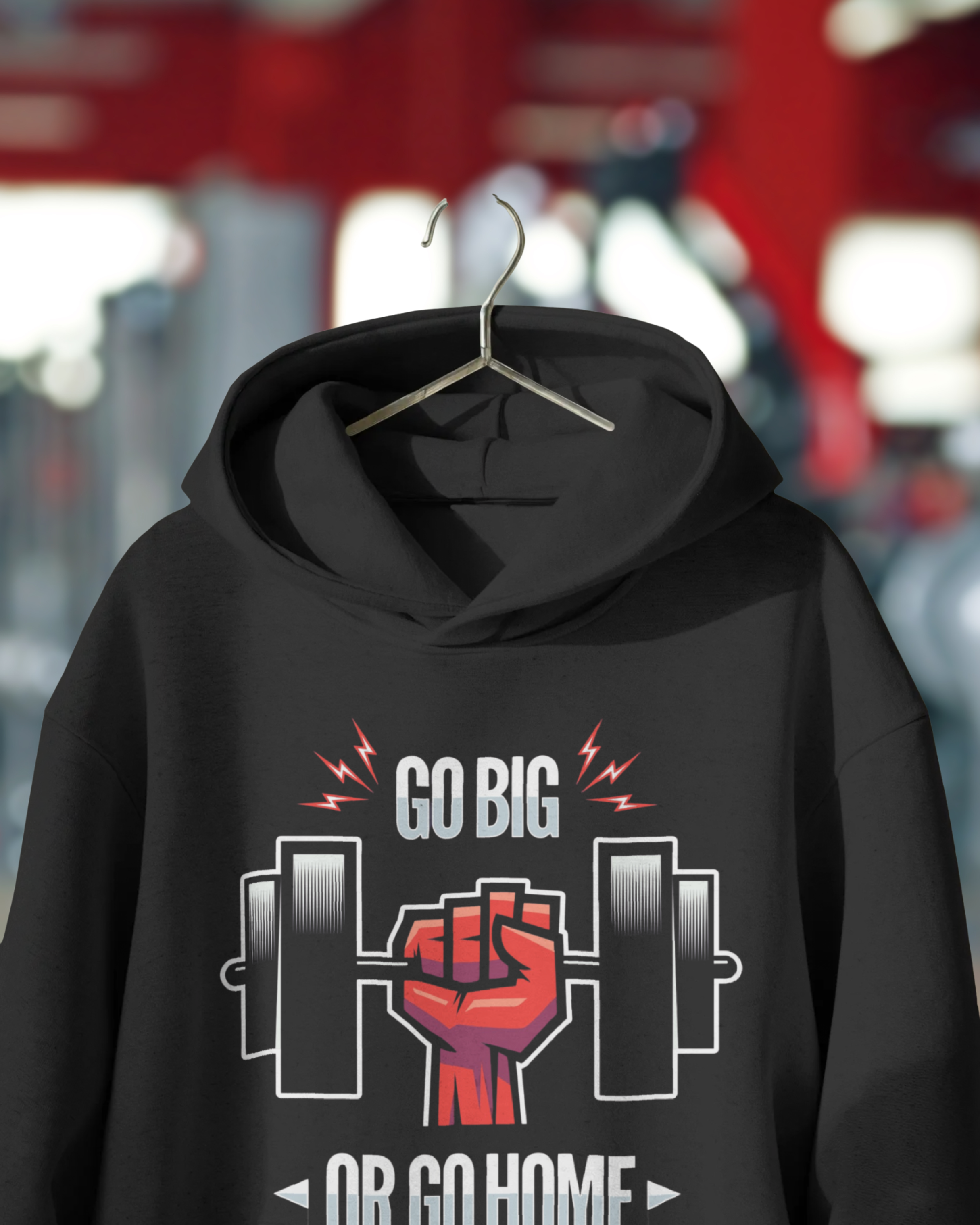Black hoodie with 'GO BIG OR GO HOME' graphic on a hanger against a blurred background