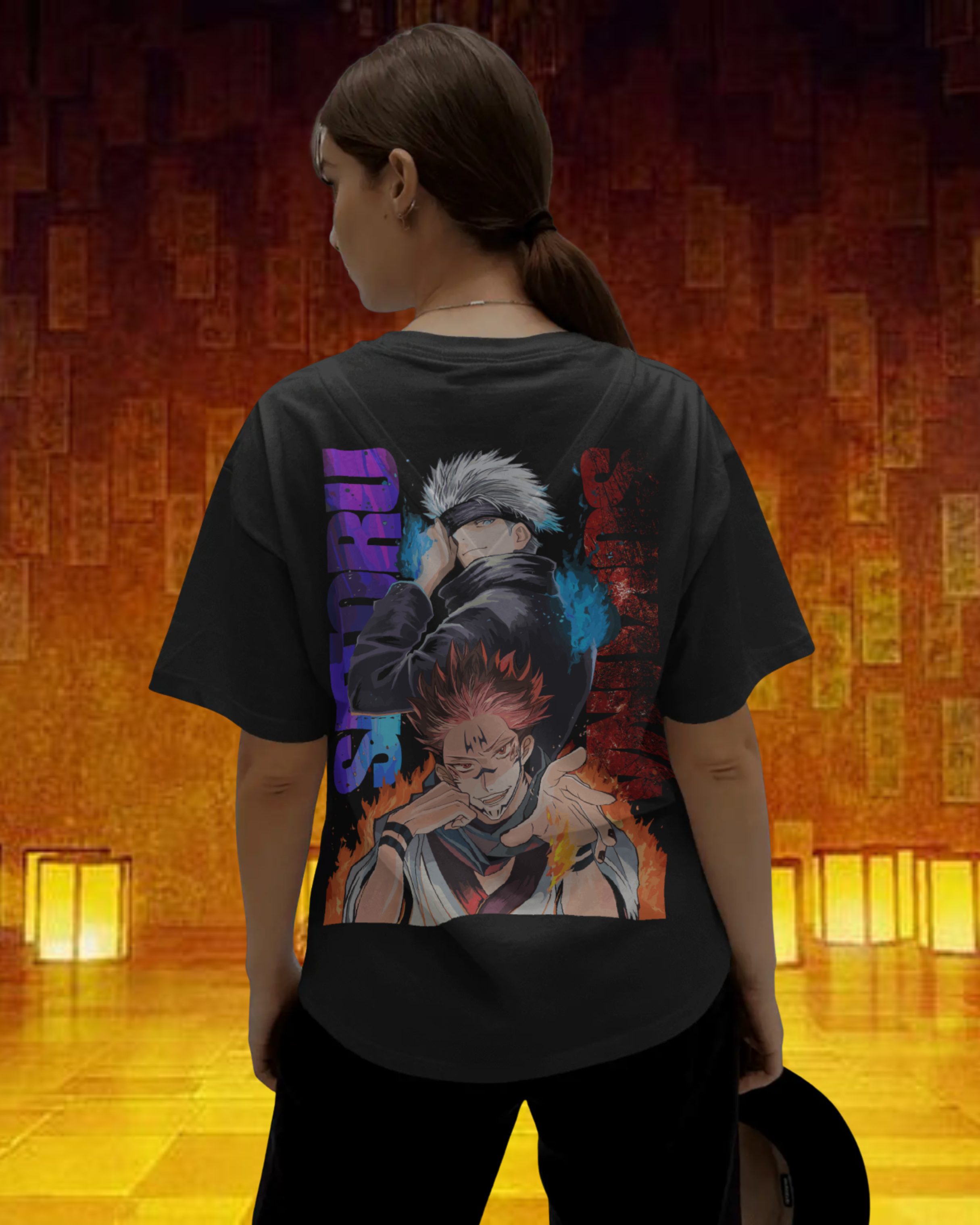 Person wearing a black t-shirt with a colorful graphic design on the back, standing in a warm-lit room