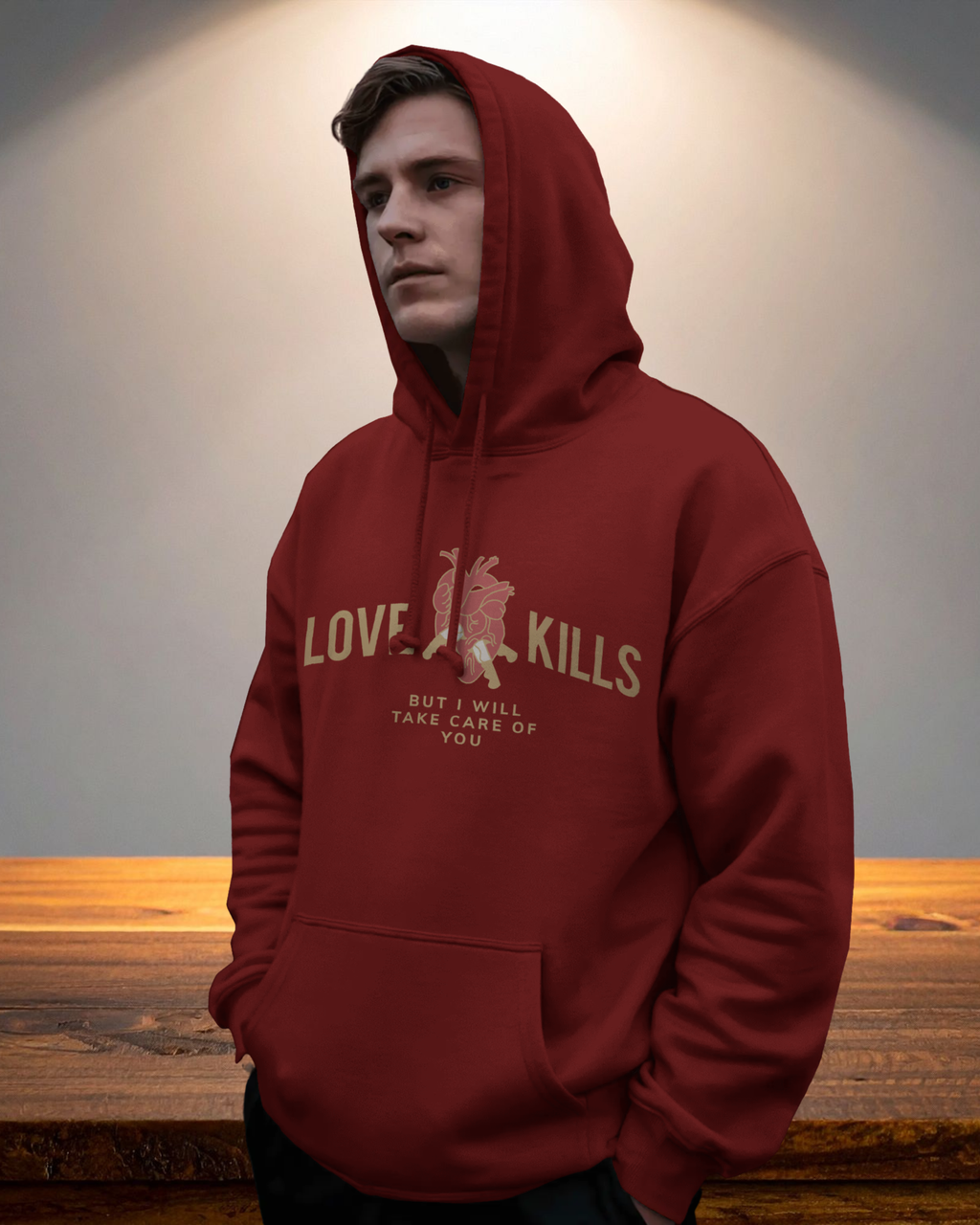 Person wearing a red hoodie with text and graphic design, standing against a neutral background